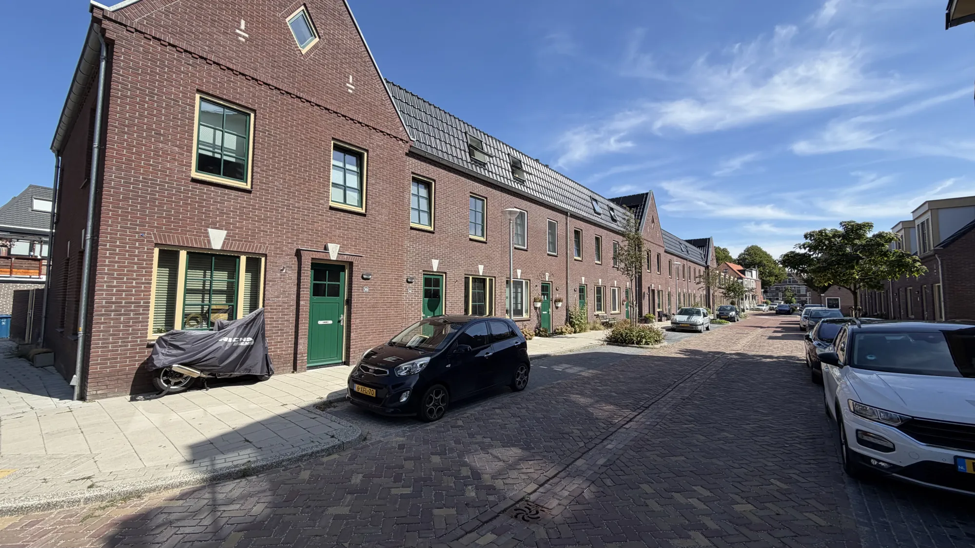 Gerealiseerde rijwoningen langs een woonstraat in Bloemwijk